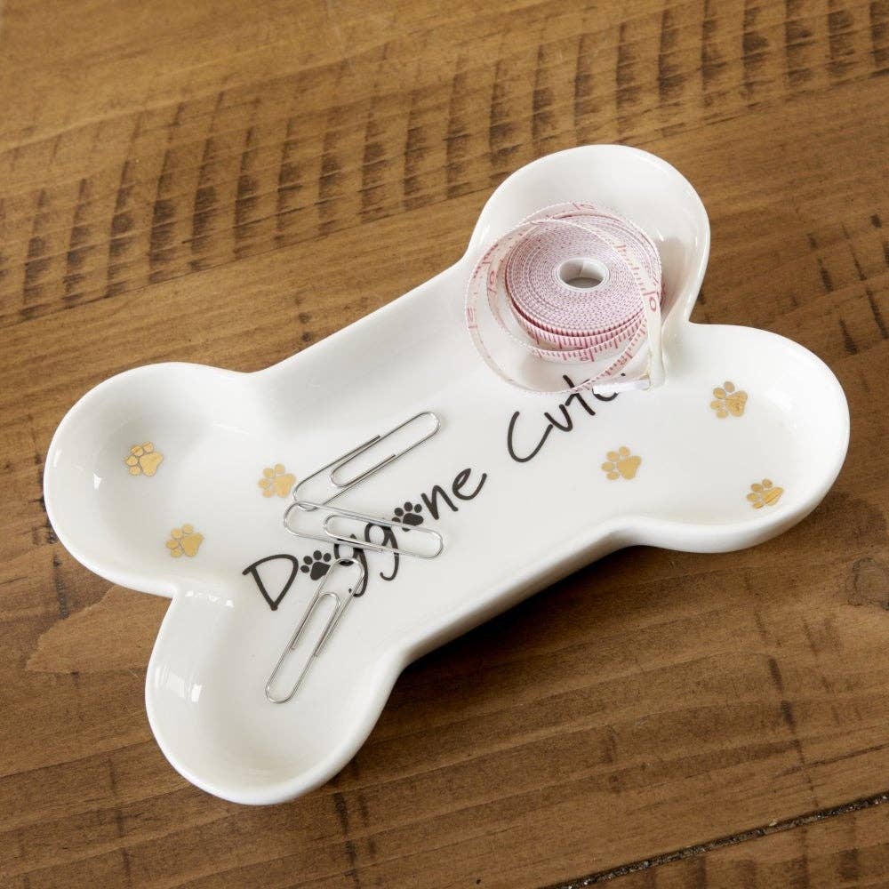 White bone-shaped tray with decorative elements on a wooden surface