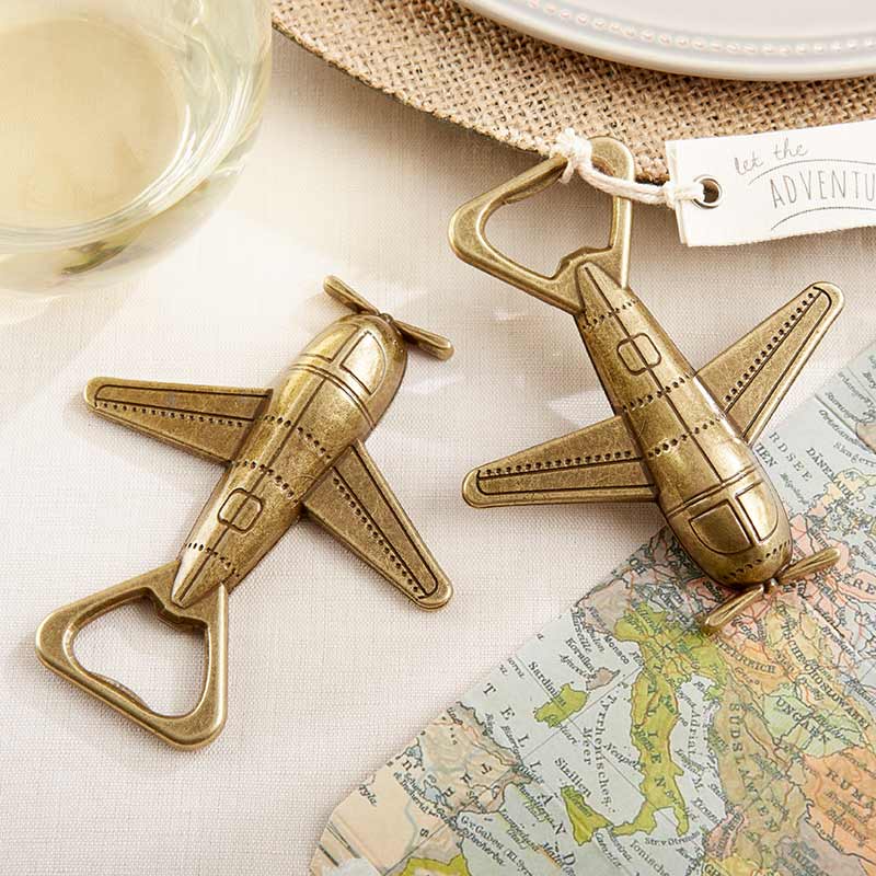 Two airplane-shaped bottle openers on a map with a glass of wine in the background.