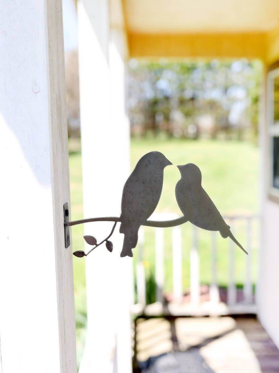 Close-up of plasma-cut steel love birds sculpture with rust patina finish