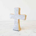 Decorative cross-shaped object with a textured surface on a white background