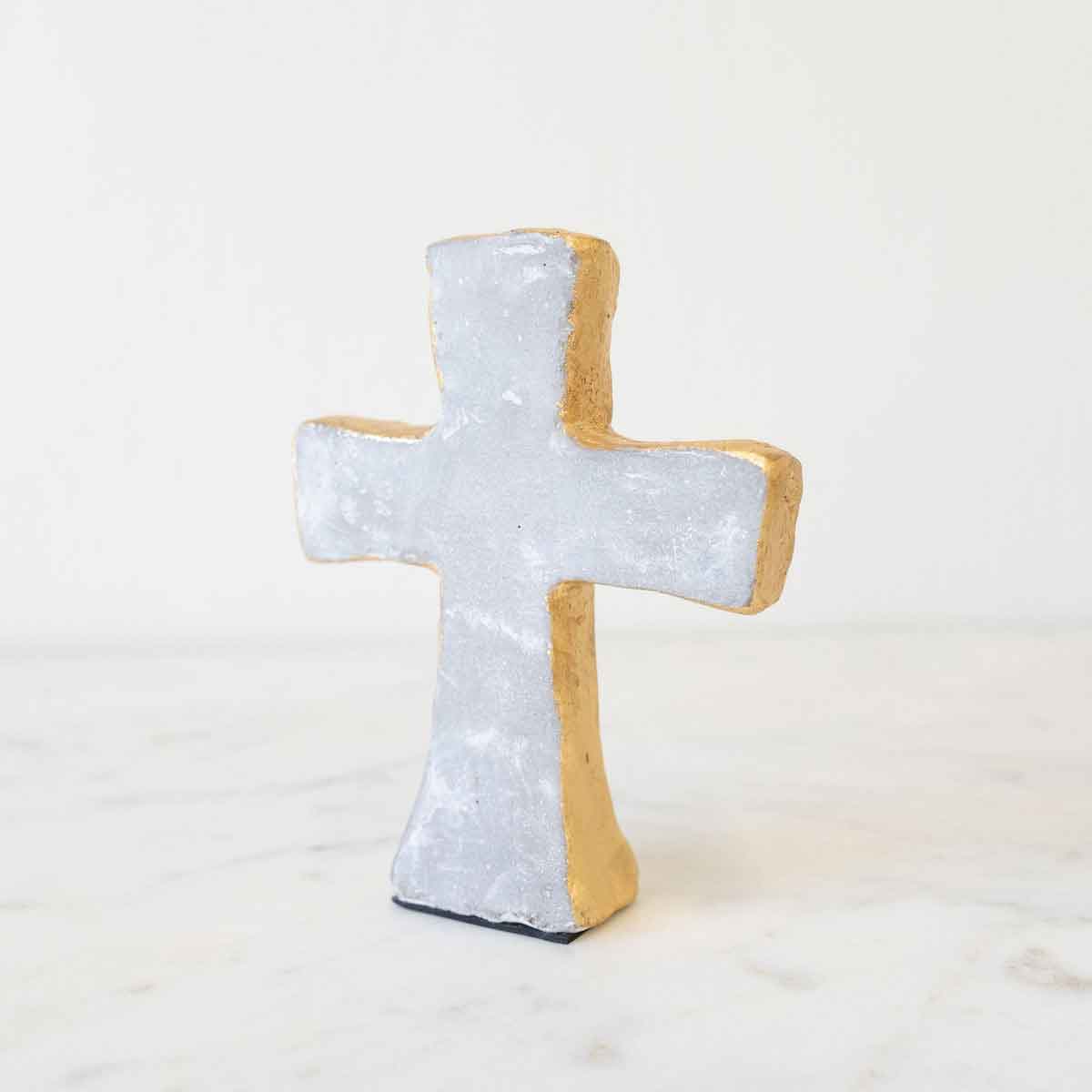 Decorative cross-shaped object with a textured surface on a white background