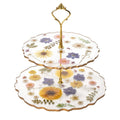 Two-tiered cake stand with floral design on a white background