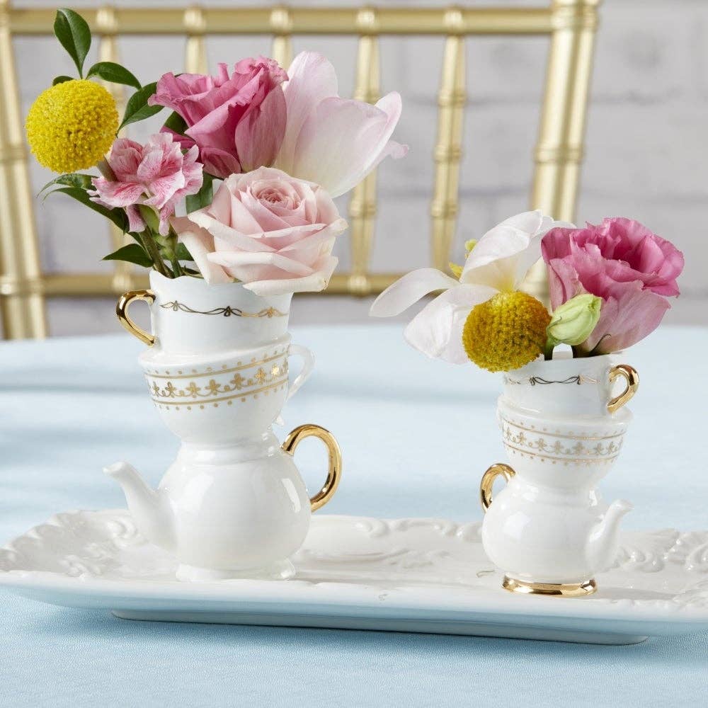 Two decorative teacups with flowers on a light blue surface.