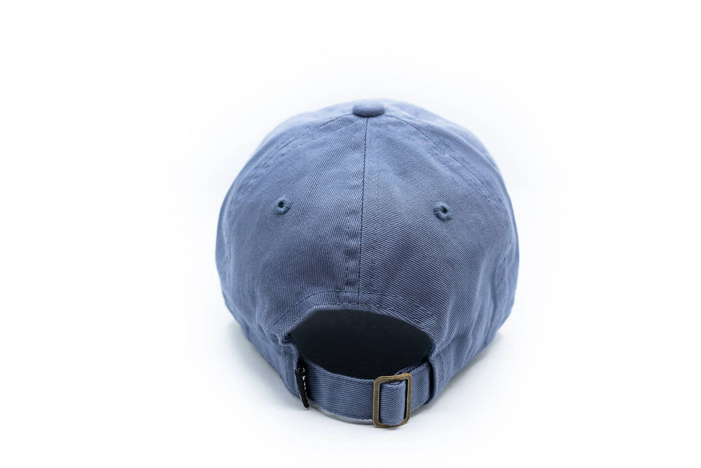 A blue cotton baseball cap shown from the back, featuring an adjustable strap with a brass buckle, on a solid white background.