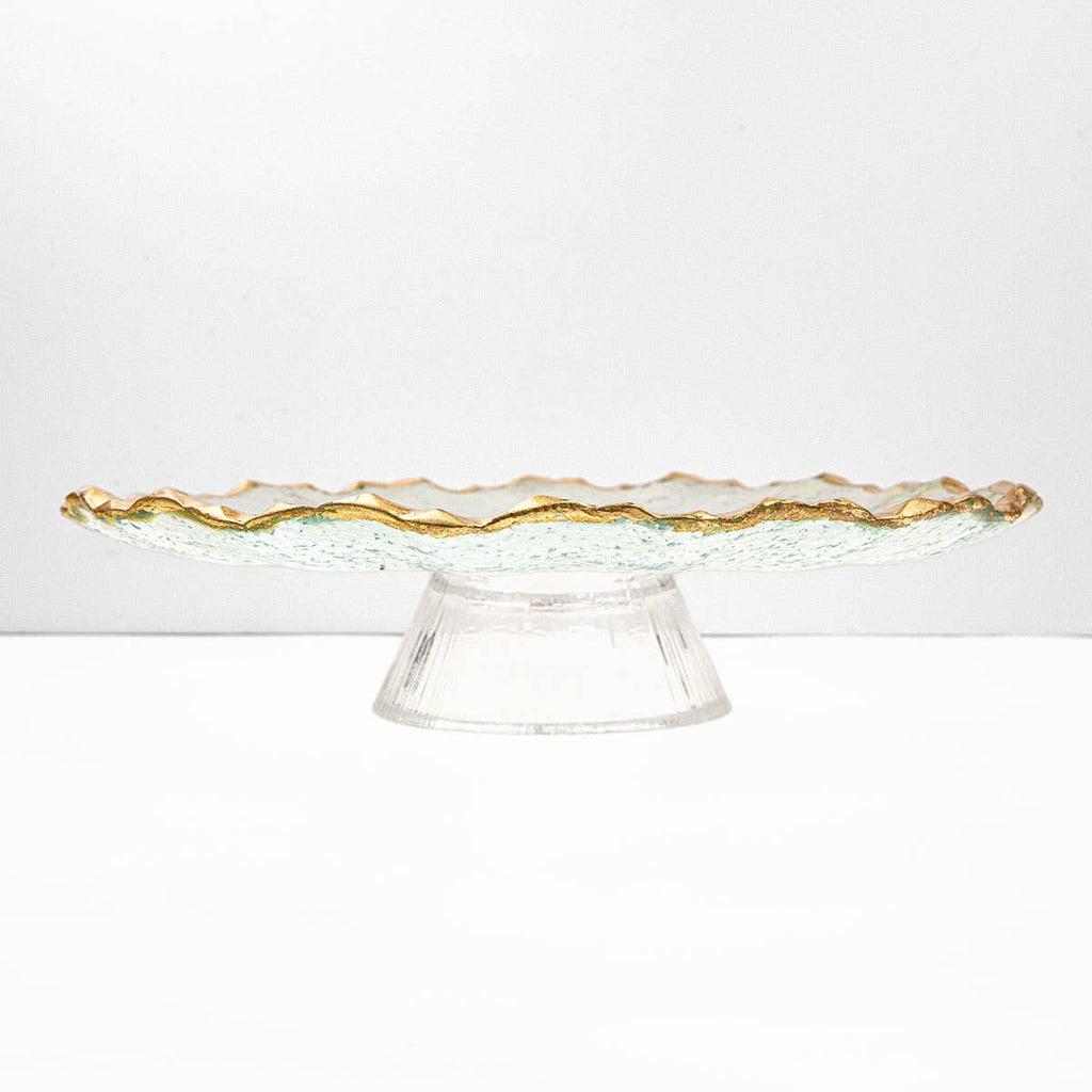 Clear glass cake stand with gold rim on a white background