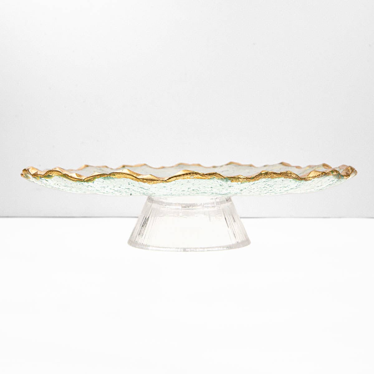Clear glass cake stand with gold rim on a white background