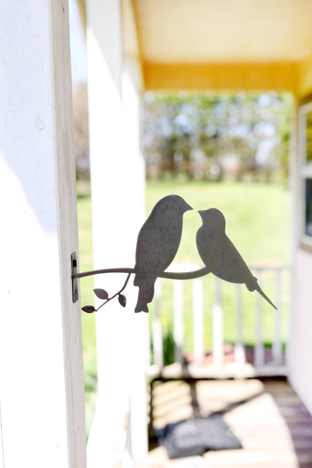 Highland Ridge handmade metal love birds statue with natural rust patina in a garden setting