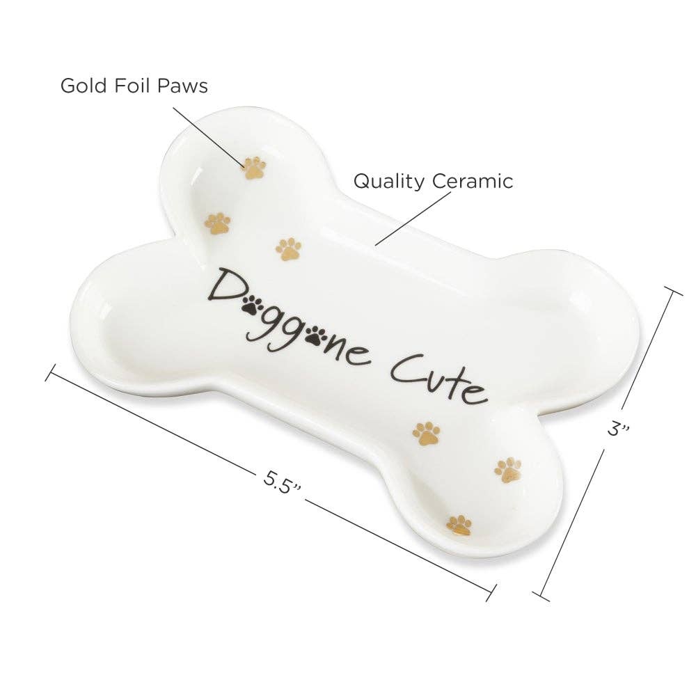 Dog bone-shaped ceramic plate with 'Doggone Cute' text and gold paw prints, labeled for dimensions and material quality.