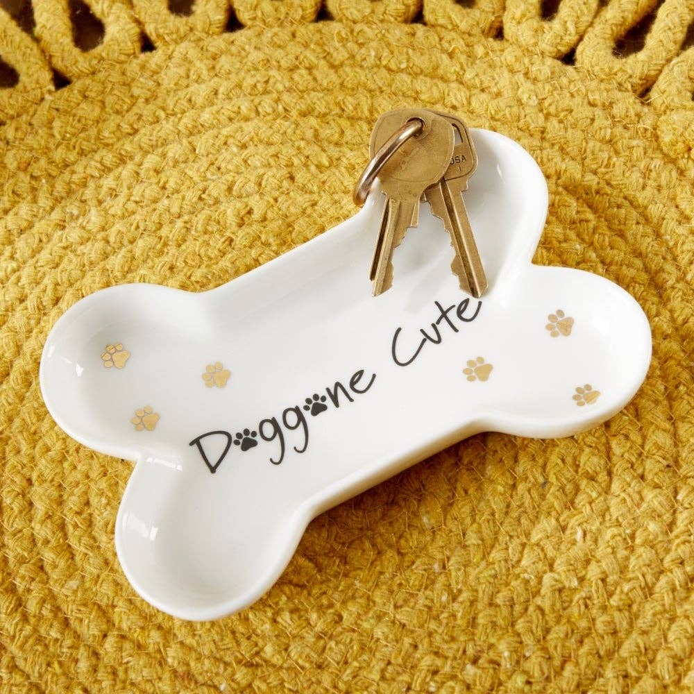 White bone-shaped key holder with 'Doggone Cute' text and keys on a yellow textured background