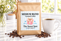 Medium Blend Ground Coffee kraft bag with Sweet Spot Gift Shop label and roasted coffee beans